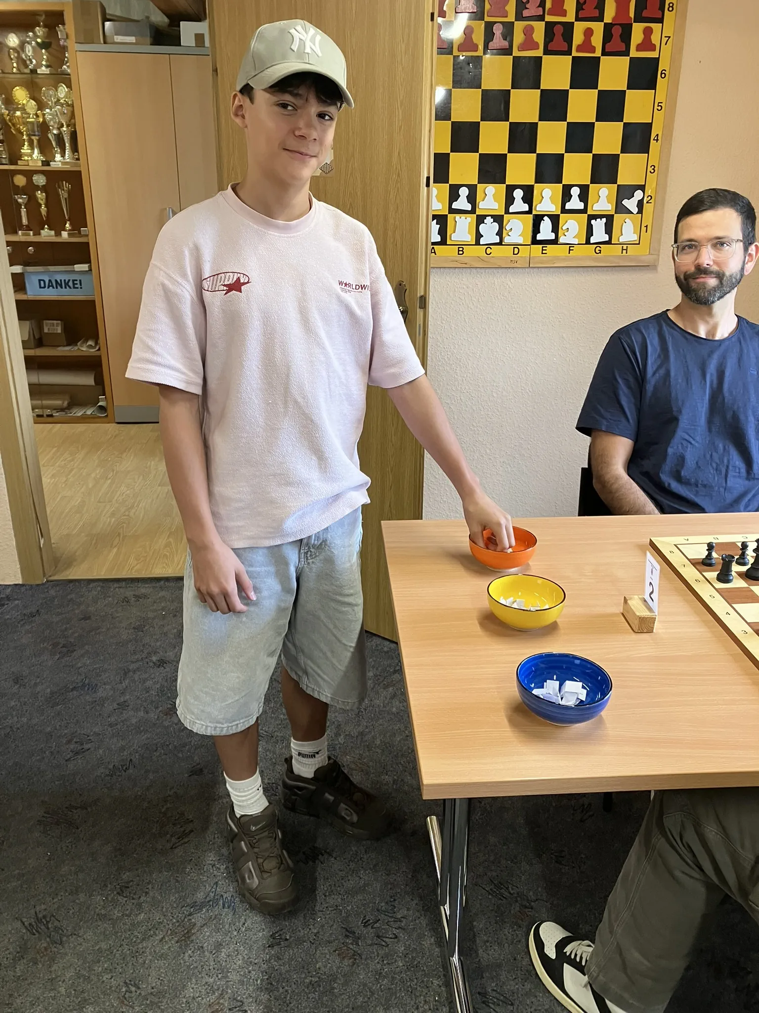 Lukas übernimmt die Live-Auslosung der Schach960-Stellungen mit drei farbigen Schalen.